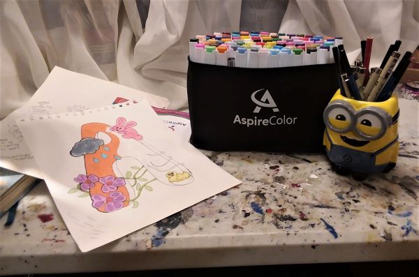 from left to right, drawing using alcohol markers, markers and minion cup with pens and pencils