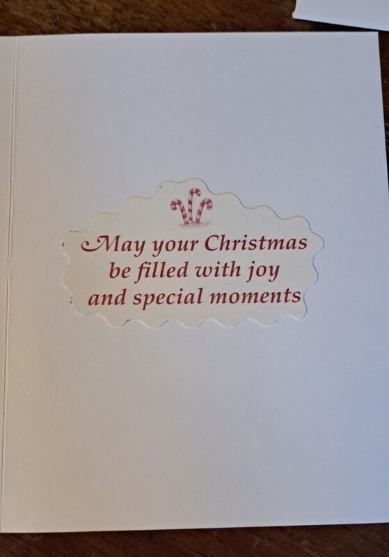 pictured inside the Christmas card with a cut out that reads May your Christmas be filled with joy and special moments.